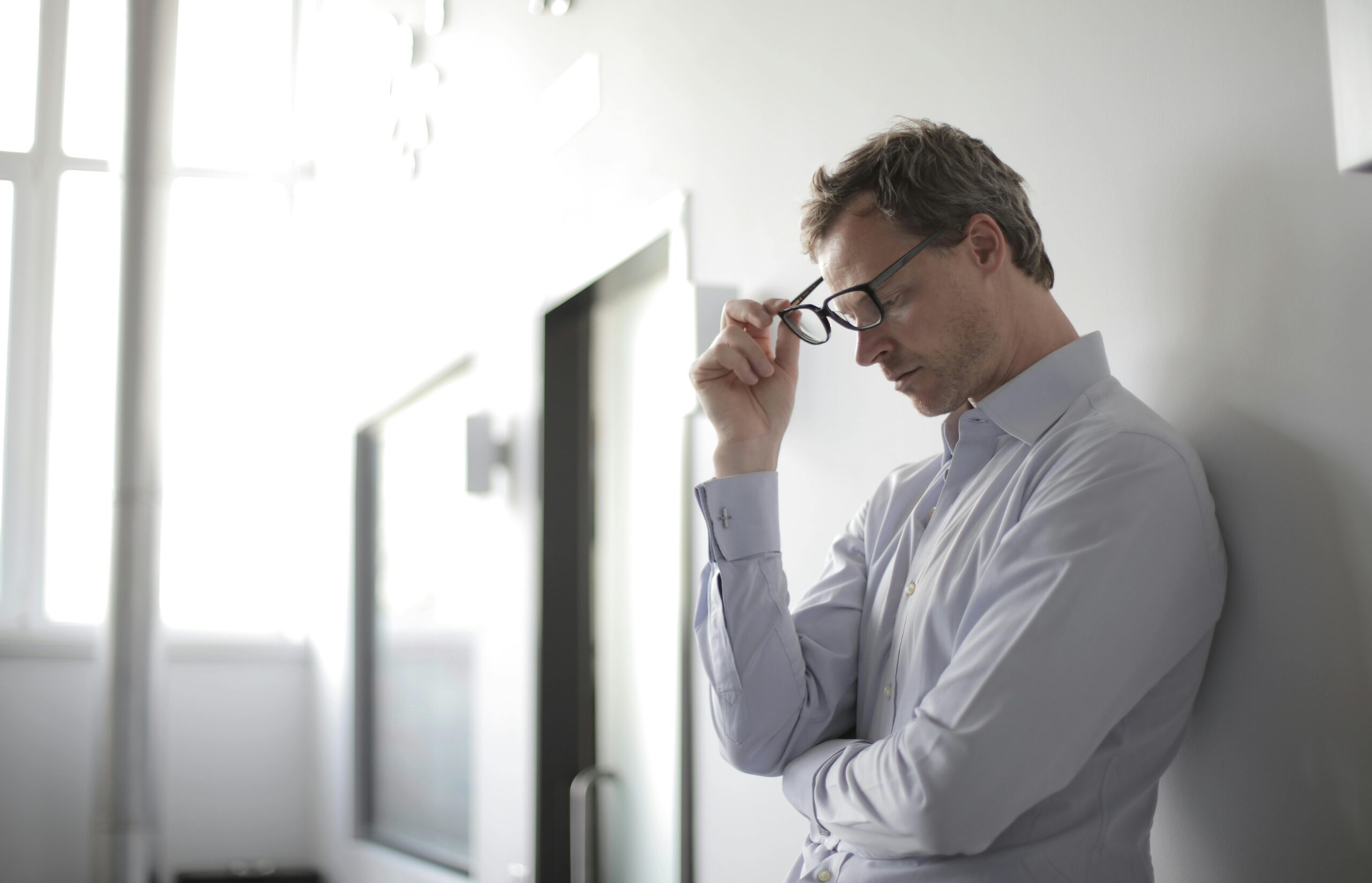 Image of a person holding their glasses on their face